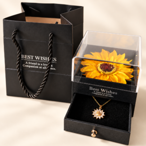 Joyero con girasol decorativo y collar floral acompañado de bolsa negra