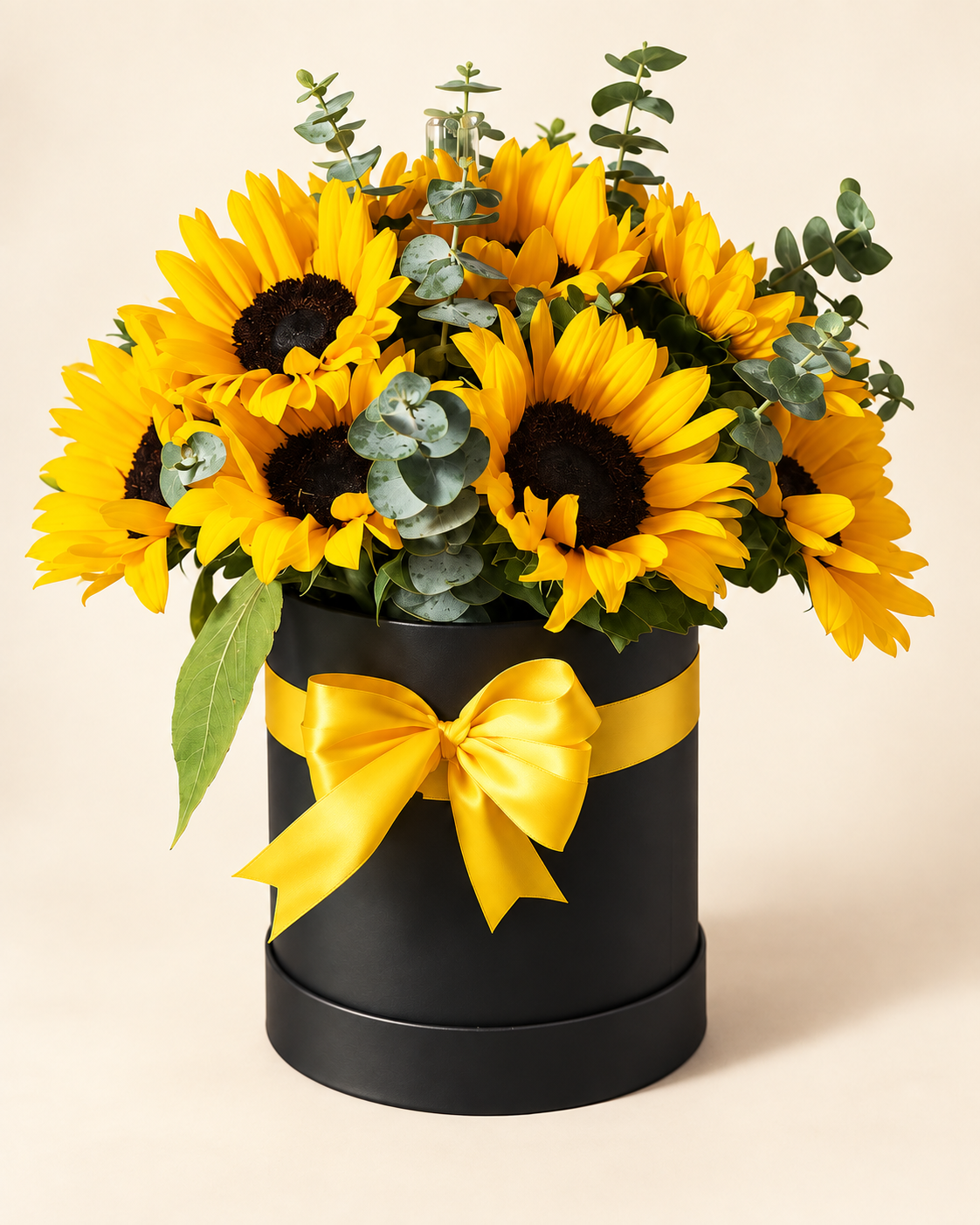 Arreglo de girasoles con follaje en caja negra y lazo amarillo