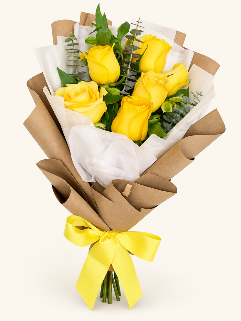 Buqué de 5 rosas amarillas con eucalipto y follaje, papel kraft y lazo amarillo. Sobre fondo crema.