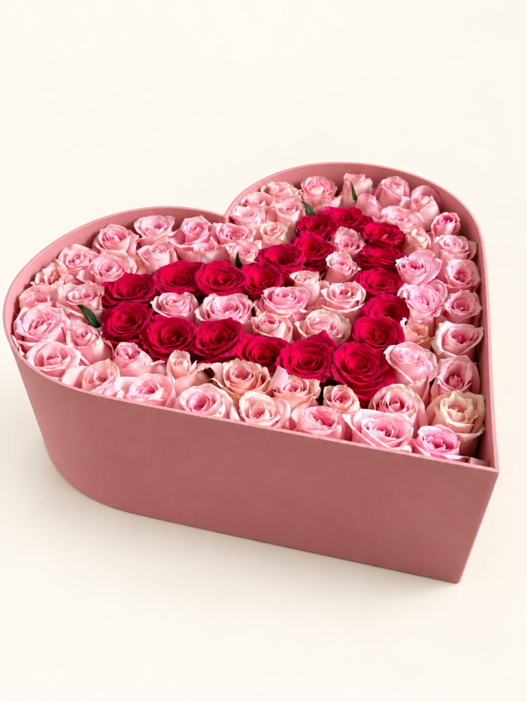 Caja corazón rosada con rosas rosadas y un corazón interior de rosas fucsias. Sobre fondo crema.
