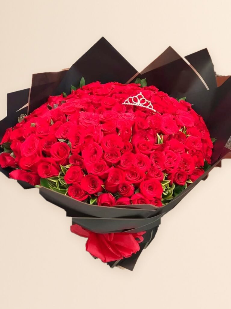 Ramo buchón de 200 rosas rojas con follaje, papel negro y tiara decorativa en Manizales sobre fondo crema