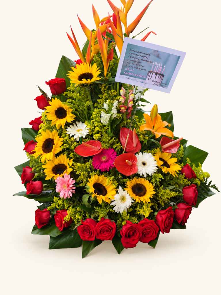 Arreglo de girasoles y rosas rojas con heliconias, anturios, gerberas, lirio y follaje. Sobre fondo crema.