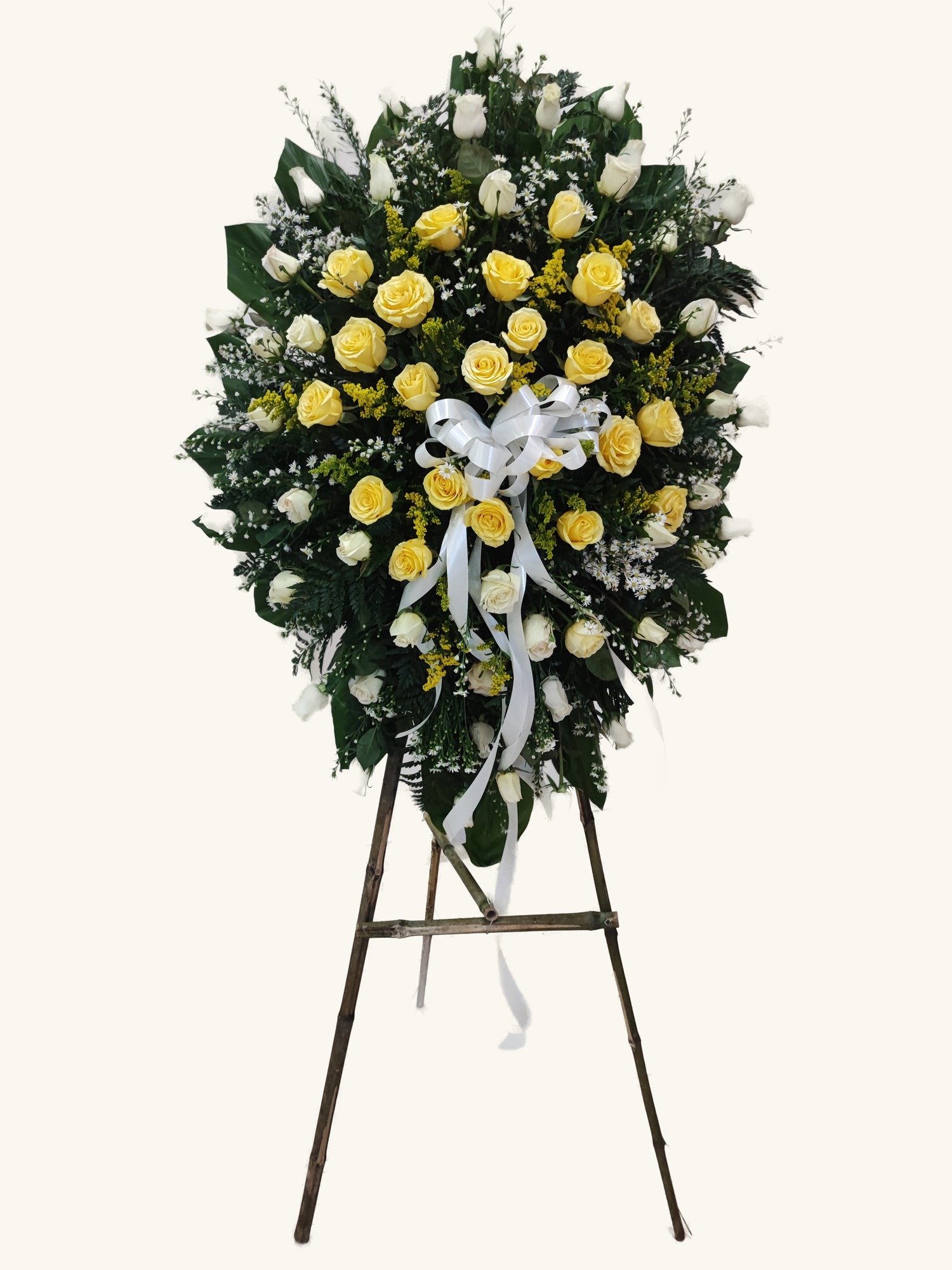 Arreglo fúnebre de rosas amarillas y blancas en pedestal para condolencias en Manizales