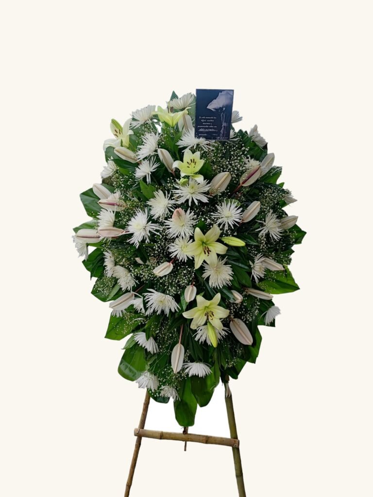 Arreglo fúnebre blanco con lirios y flores de temporada para condolencias en Manizales