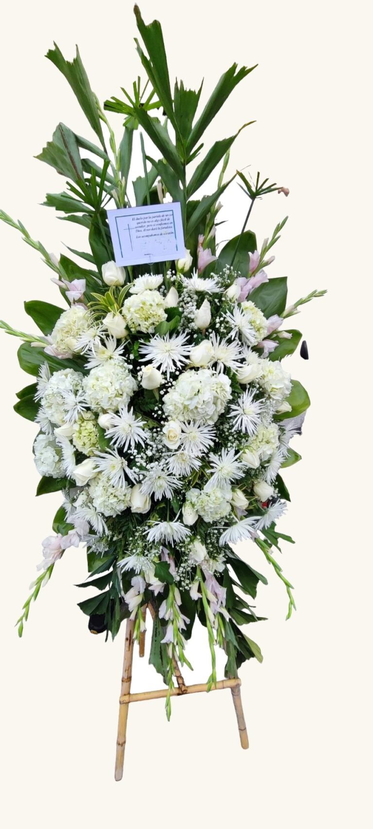 Arreglo fúnebre blanco de rosas y follaje para condolencias en Manizales