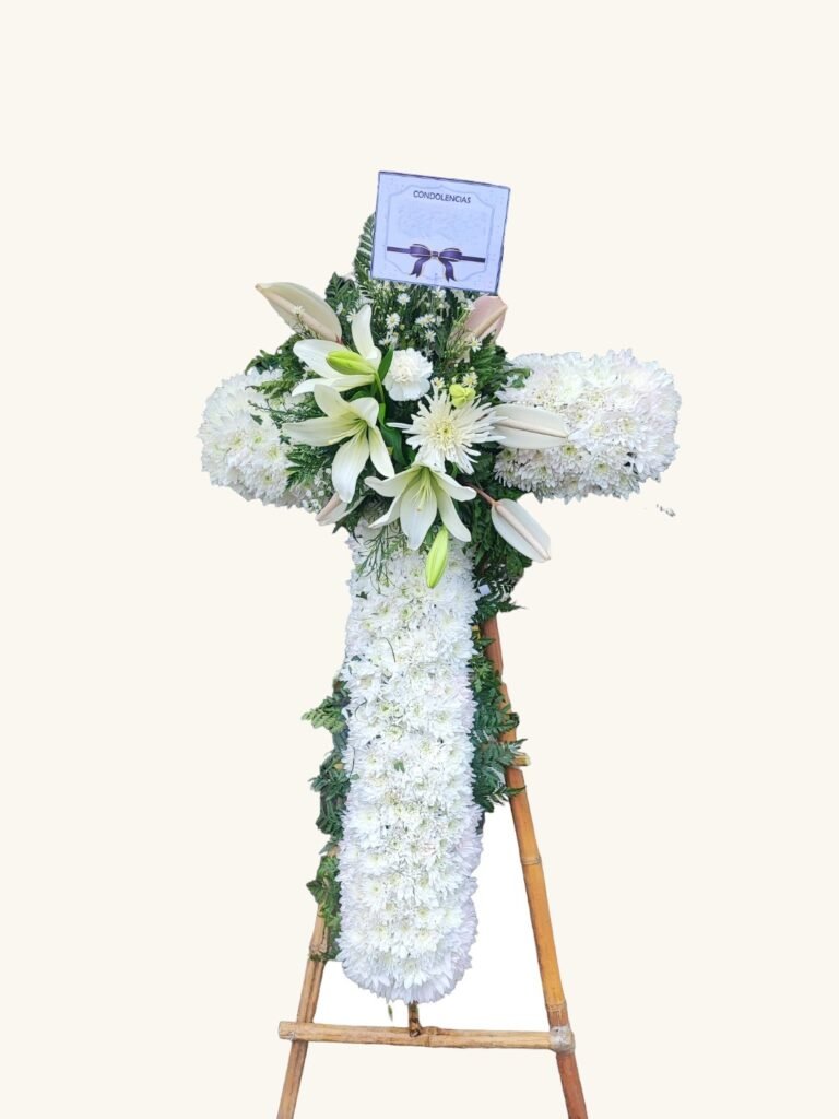Cruz fúnebre de lirios blancos y flores de temporada para condolencias en Manizales