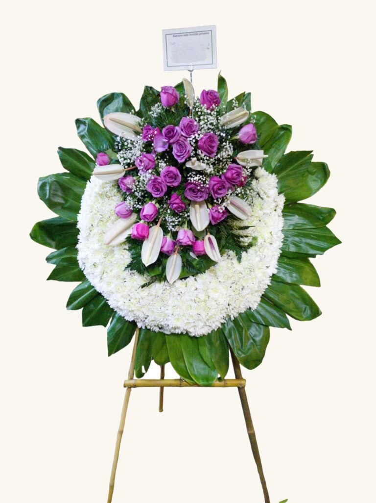 Corona fúnebre de rosas moradas con flores blancas para condolencias en Manizales