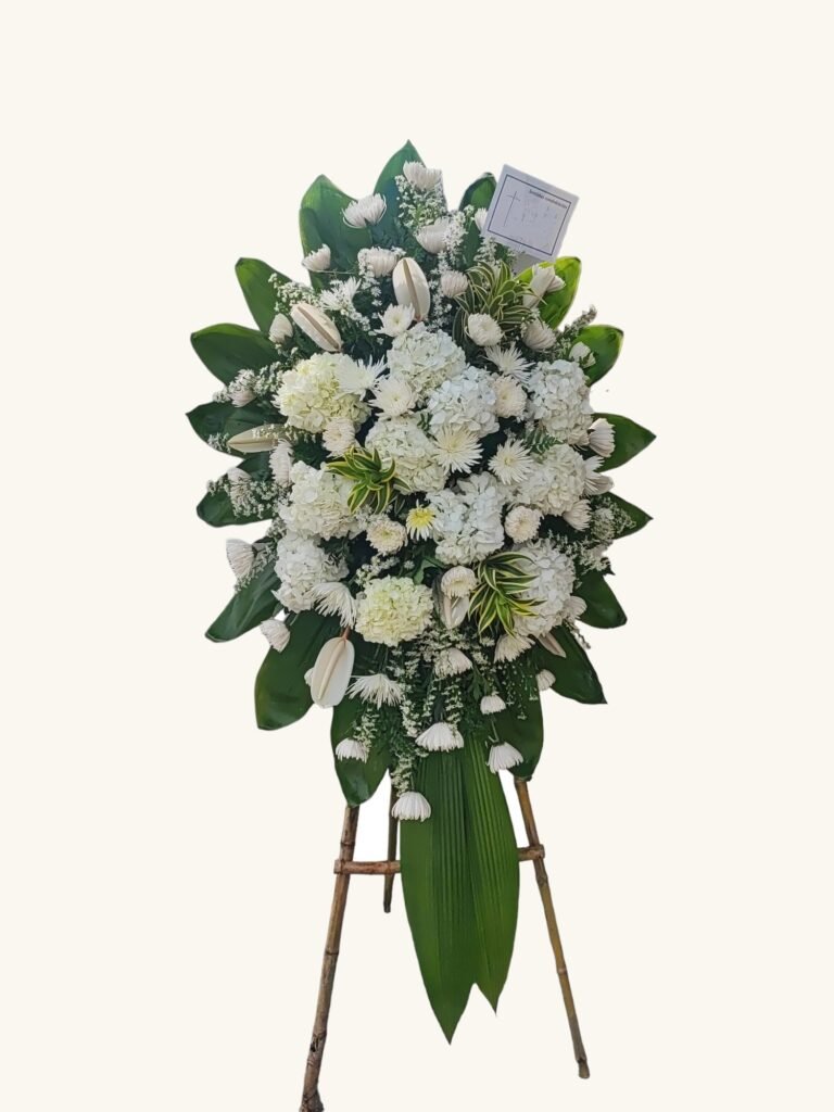 Arreglo fúnebre de lirios y rosas blancas para condolencias en Manizales