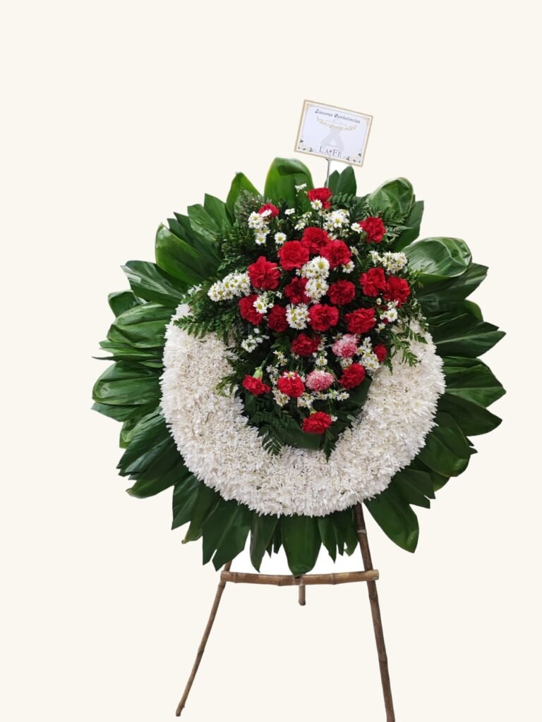 Corona fúnebre de claveles rojos y flores blancas para condolencias en Manizales