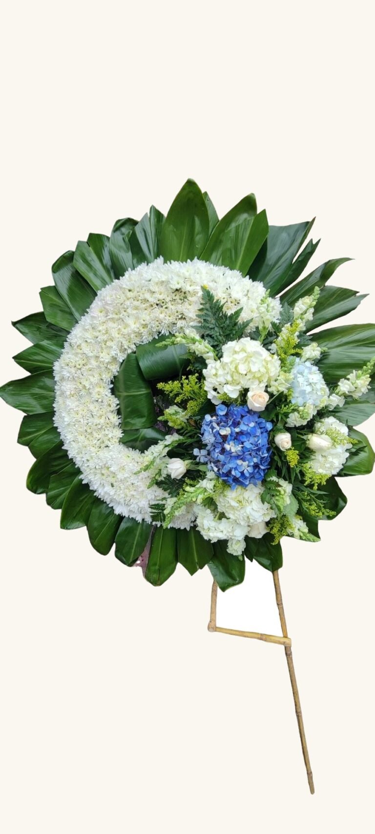 Corona fúnebre blanca con hortensia azul para condolencias en Manizales