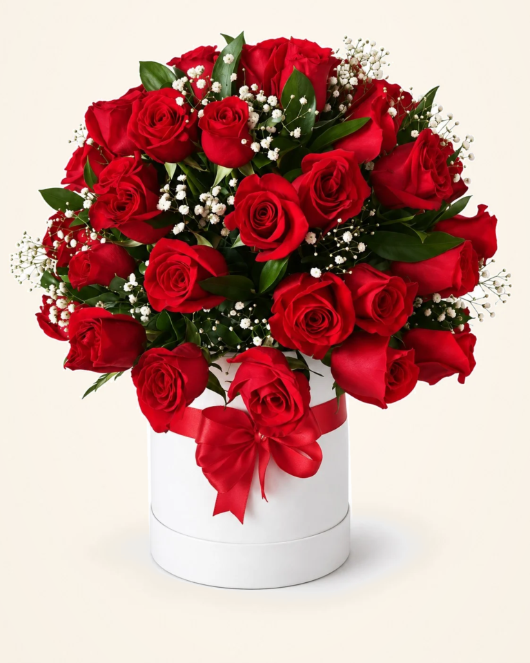 Rosas rojas con follaje en caja redonda blanca